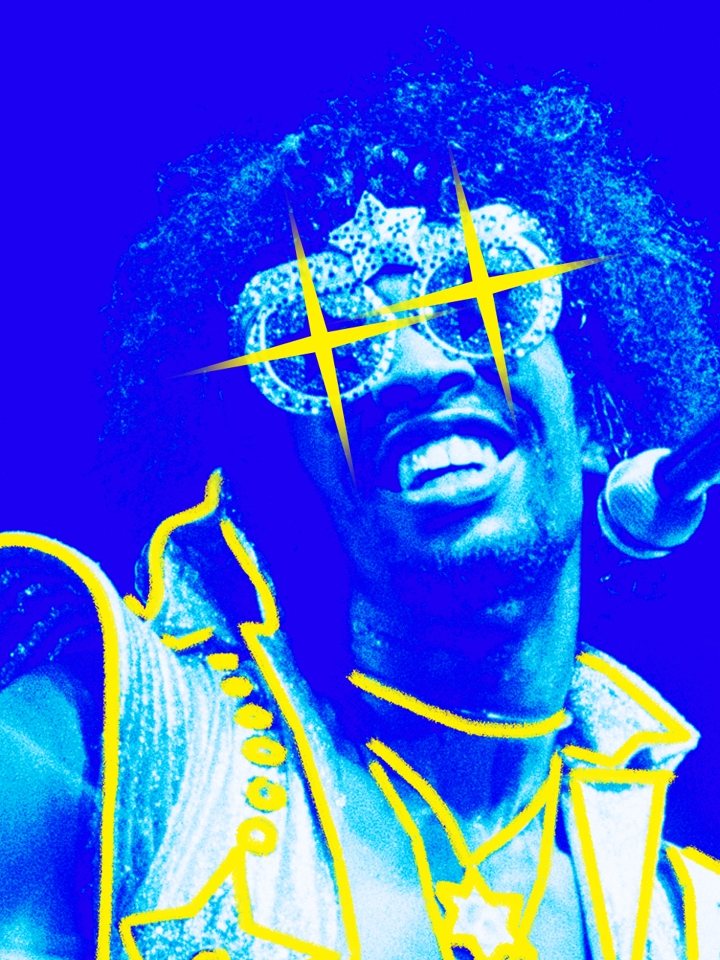 Bootsy Collins in rhinestone star-shaped glasses, singing into a microphone.